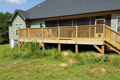 Example of a large backyard deck design in Other
