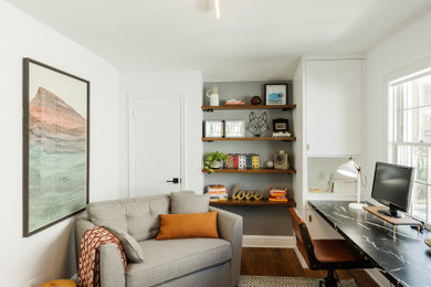 Imagen de despacho ecléctico con paredes blancas, suelo de madera en tonos medios y escritorio empotrado