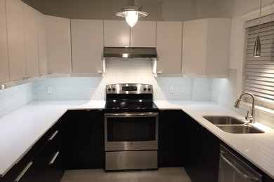 Photo of a small contemporary u-shaped open plan kitchen in Toronto with flat-panel cabinets, white cabinets, grey splashback, metro tiled splashback, stainless steel appliances, a double-bowl sink, composite countertops, porcelain flooring, no island and beige floors.