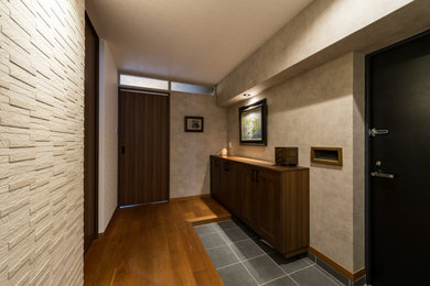 福岡にあるおしゃれな玄関ホール (グレーの壁、合板フローリング、黒いドア、マルチカラーの床、クロスの天井、壁紙、白い天井) の写真