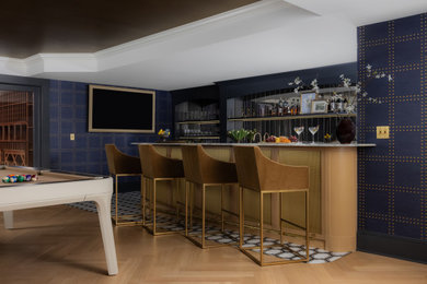 Inspiration for a large transitional galley light wood floor seated home bar remodel in New York with an undermount sink, shaker cabinets, blue cabinets, onyx countertops, multicolored backsplash, mirror backsplash and gray countertops