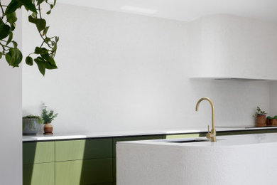 Mid-sized contemporary kitchen pantry in Melbourne with an undermount sink, flat-panel cabinets, green cabinets, quartz benchtops, white splashback, black appliances, terrazzo floors, with island, grey floor and white benchtop.