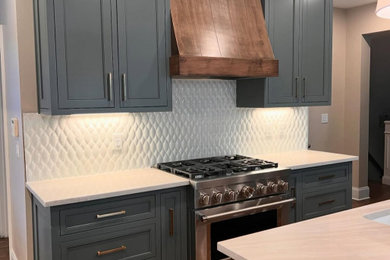 Large transitional galley medium tone wood floor eat-in kitchen photo in Atlanta with shaker cabinets, blue cabinets, quartzite countertops, white backsplash, mosaic tile backsplash, stainless steel appliances, an island, beige countertops and a single-bowl sink