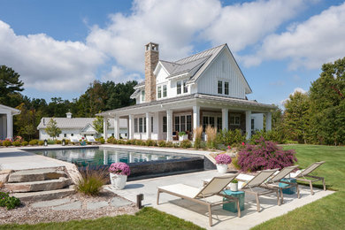 Inspiration for a huge farmhouse white two-story wood exterior home remodel in Grand Rapids with a metal roof