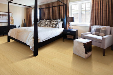 Photo of a large modern master bedroom in Seattle with beige walls and light hardwood floors.