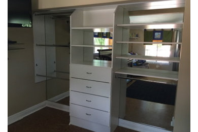 Example of a mid-sized arts and crafts gender-neutral reach-in closet design in Other with flat-panel cabinets