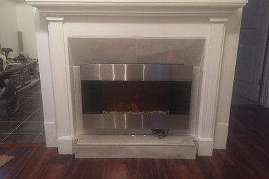 Living room - small transitional formal and enclosed medium tone wood floor living room idea in Cleveland with white walls, a standard fireplace, a tile fireplace and a wall-mounted tv