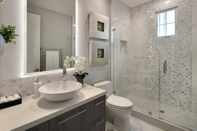 Inspiration for a small modern 3/4 bathroom in Orange County with flat-panel cabinets, dark wood cabinets, an alcove shower, a one-piece toilet, white tile, porcelain tile, grey walls, porcelain floors, a vessel sink, engineered quartz benchtops, white floor, a hinged shower door and white benchtops.