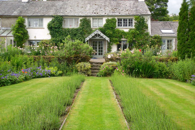Inspiration for a country front formal garden in Other with a flowerbed.