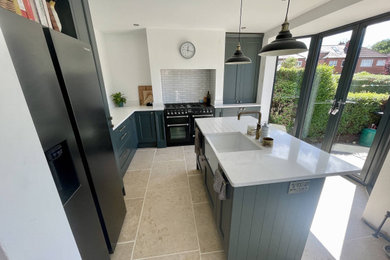 Inspiration for a small l-shaped enclosed kitchen in Other with blue cabinets, quartz worktops, white splashback, ceramic splashback, black appliances, an island and white worktops.