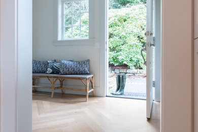 Entryway - small traditional light wood floor and brown floor entryway idea in Seattle with white walls and a white front door