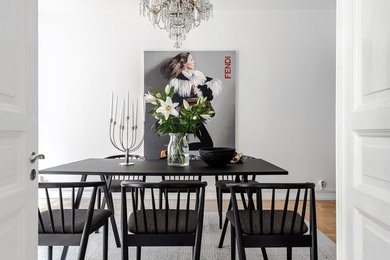 This is an example of a large modern separate dining room in Gothenburg with white walls, medium hardwood floors, no fireplace and brown floor.