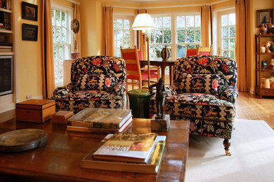 Example of a large transitional open concept light wood floor living room design in Seattle with yellow walls and a media wall