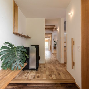 横浜のアジアンスタイルのおしゃれな玄関ホール (白い壁、無垢フローリング、茶色い床) の写真