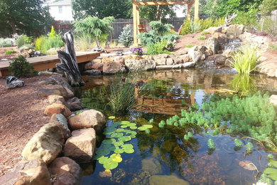 Photo of a large full sun backyard mulch water fountain landscape in Austin.