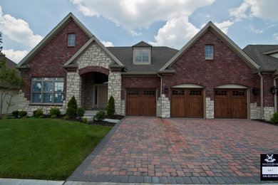 Large trendy two-story brick exterior home photo in St Louis