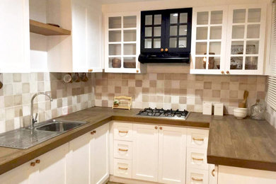 Enclosed kitchen - small cottage u-shaped ceramic tile and brown floor enclosed kitchen idea in Other with an integrated sink, glass-front cabinets, white cabinets, tile countertops, brown backsplash, porcelain backsplash, black appliances and brown countertops