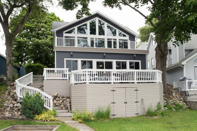 Transitional blue two-story vinyl and clapboard house exterior idea in Other with a shingle roof