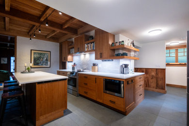 Inspiration for a mid-sized craftsman ceramic tile and gray floor kitchen remodel in Boston with shaker cabinets, medium tone wood cabinets, quartz countertops, white backsplash, cement tile backsplash, stainless steel appliances, an island, white countertops and an undermount sink
