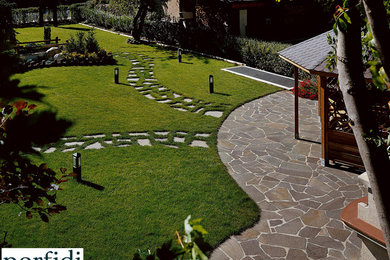 Immagine di un grande giardino minimalista esposto in pieno sole con sassi e rocce e pavimentazioni in pietra naturale