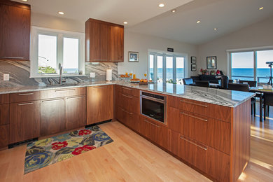 Kitchen pantry - mid-sized contemporary l-shaped light wood floor and brown floor kitchen pantry idea in Boston with an undermount sink, flat-panel cabinets, medium tone wood cabinets, quartz countertops, gray backsplash, stone slab backsplash, stainless steel appliances, a peninsula and gray countertops