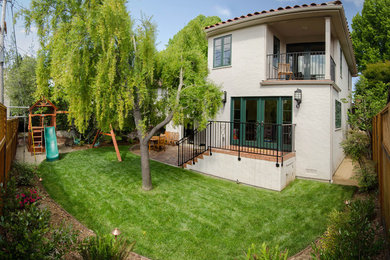 Mid-sized mediterranean beige two-story adobe flat roof idea in San Francisco