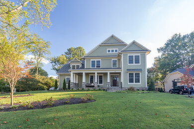 Inspiration for a large craftsman green two-story wood exterior home remodel in DC Metro with a shingle roof