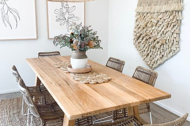 Dining room - coastal laminate floor dining room idea in Melbourne with white walls