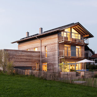 Mittelgroßes, Zweistöckiges, Braunes Skandinavisches Einfamilienhaus mit Holzfassade, Satteldach und Ziegeldach in München