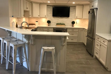 Mid-sized transitional u-shaped dark wood floor kitchen photo in Chicago with shaker cabinets, white cabinets, marble countertops, white backsplash, marble backsplash, stainless steel appliances and a peninsula