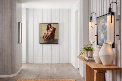 Hallway - contemporary light wood floor and wall paneling hallway idea in Austin with white walls