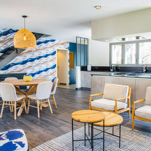 Inspiration pour une salle à manger ouverte sur le salon design avec un mur blanc, un sol en bois foncé et un sol marron.