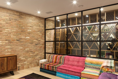 Design ideas for an eclectic wine cellar in London with light hardwood floors and display racks.