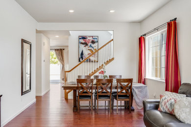 Large trendy formal and open concept laminate floor, brown floor and vaulted ceiling living room photo in San Francisco with white walls, no fireplace and a tv stand