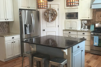 Kitchen - mid-sized transitional l-shaped medium tone wood floor and brown floor kitchen idea in Austin with raised-panel cabinets, white cabinets, granite countertops, brown backsplash, ceramic backsplash, stainless steel appliances and an island