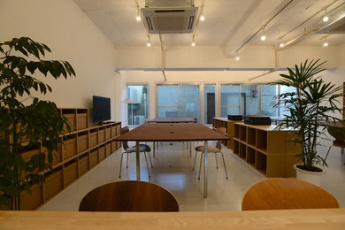 Foto de estudio minimalista sin chimenea con paredes blancas, suelo de piedra caliza y escritorio independiente