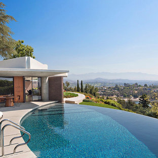 ロサンゼルスの円形ミッドセンチュリースタイルのおしゃれなインフィニティプール (コンクリート板舗装	) の写真