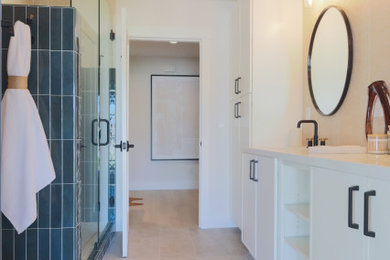 Large transitional kids' beige tile and porcelain tile porcelain tile, beige floor and double-sink corner shower photo in Phoenix with shaker cabinets, white cabinets, white walls, an undermount sink, quartz countertops, a hinged shower door, white countertops and a niche