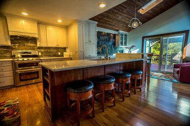 Foto på ett mellanstort vintage kök, med en undermonterad diskho, luckor med infälld panel, skåp i ljust trä, granitbänkskiva, grått stänkskydd, stänkskydd i marmor, rostfria vitvaror, mellanmörkt trägolv, en köksö och brunt golv