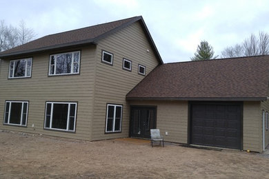 Mid-sized elegant beige two-story wood gable roof photo in Other