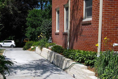 This is an example of a large traditional partial sun front yard brick driveway in Other.