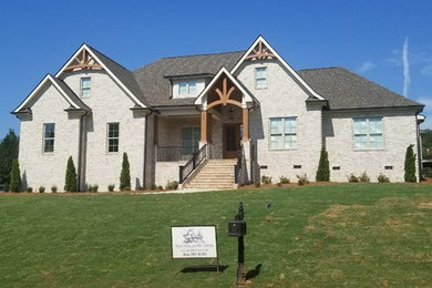 Traditional two-story brick house exterior idea in Other with a shingle roof