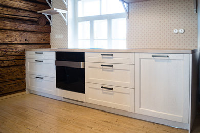 Eat-in kitchen - small country single-wall eat-in kitchen idea in Other with recessed-panel cabinets, white cabinets and wood countertops
