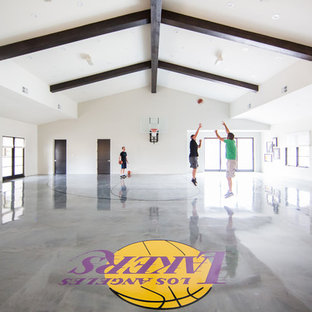 サンディエゴの巨大な地中海スタイルのおしゃれな室内コート (白い壁、コンクリートの床、グレーの床) の写真