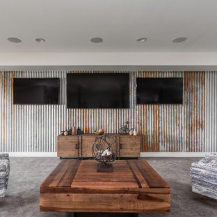 This is an example of an expansive farmhouse open plan home cinema in Indianapolis with multi-coloured walls, carpet, a wall mounted tv and grey floors.