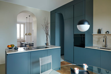 Ispirazione per un cucina con isola centrale design di medie dimensioni con lavello sottopiano, ante blu, top in marmo e paraspruzzi in marmo