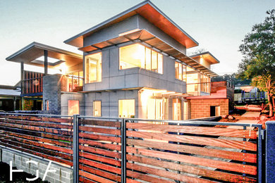 Idéer för mellanstora funkis flerfärgade hus, med två våningar, fiberplattor i betong, platt tak och tak i metall