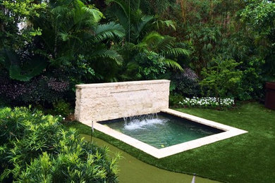 Large contemporary backyard partial sun garden in Miami with a water feature and natural stone pavers for summer.