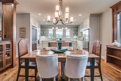 Inspiration for a mid-sized craftsman medium tone wood floor and brown floor kitchen/dining room combo remodel in Oklahoma City with beige walls and a corner fireplace