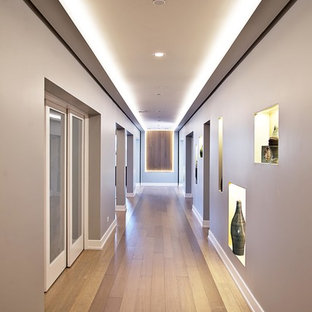 Diseño de sótano con ventanas clásico renovado, grande, sin chimenea, con paredes grises y suelo de bambú